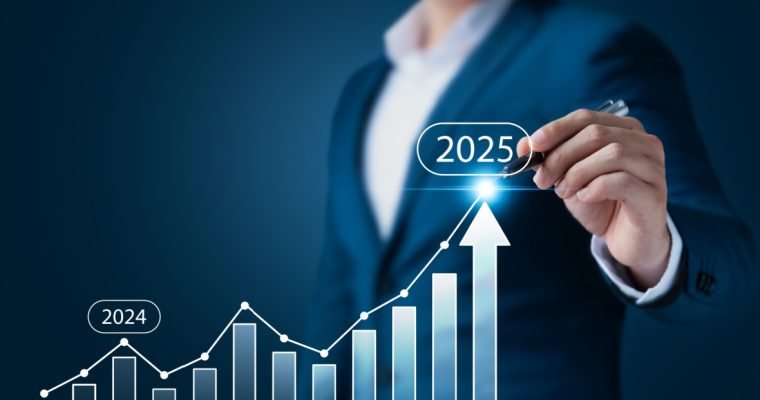 Business professional drawing an upward growth trend on a digital bar chart, highlighting a rise from 2024 to 2025